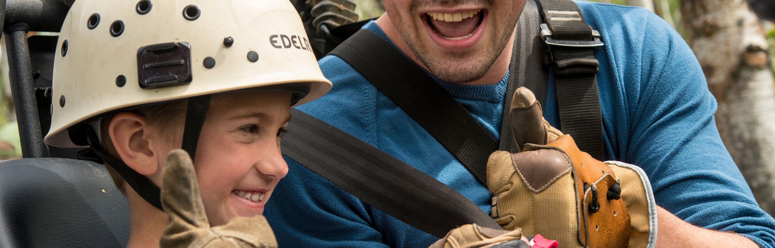 kid and older brother on zipline aerial park tour